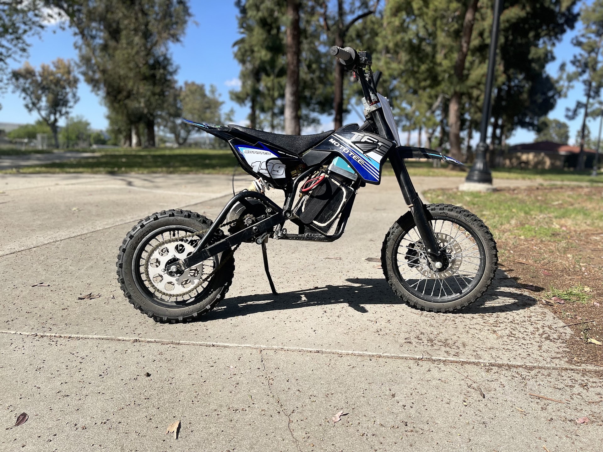 Blue electric mini dirt bike outdoors after service